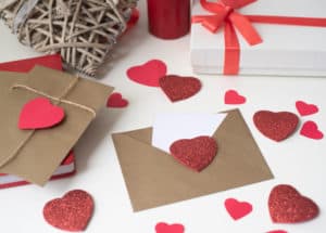 Brown envelopes with white paper and red hearts